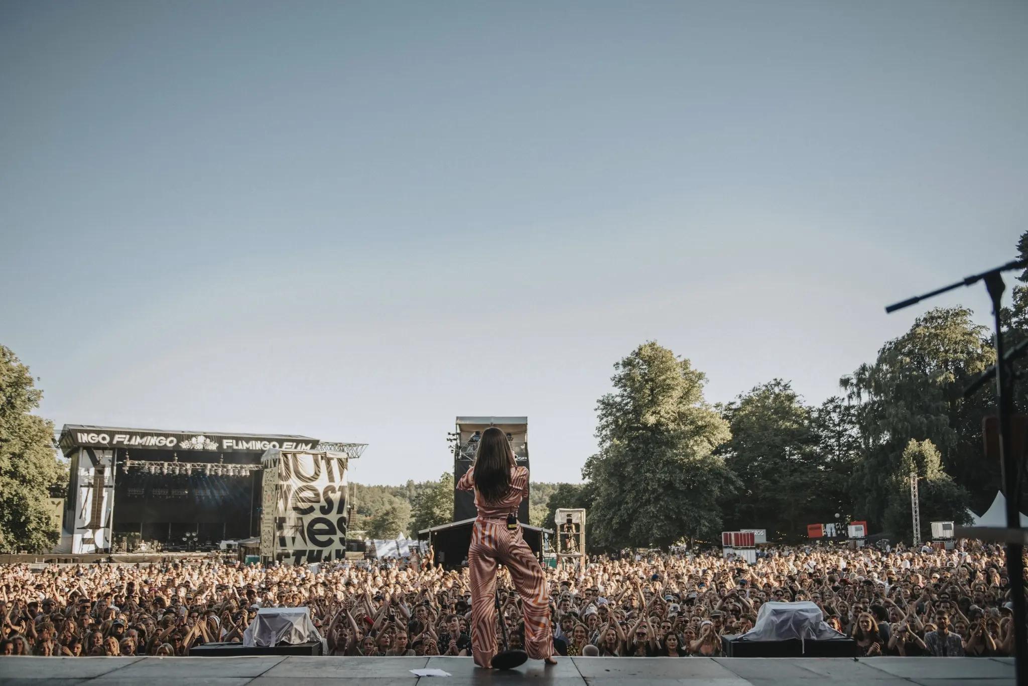 A woman on stage singing to the crowd